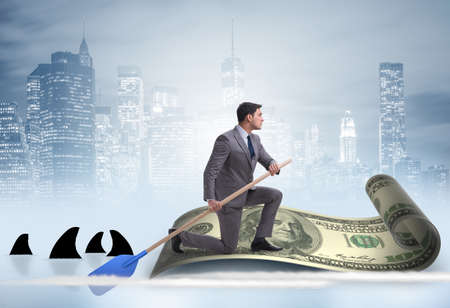 Businessman rowing on dollar boat in business financial conceptの写真素材
