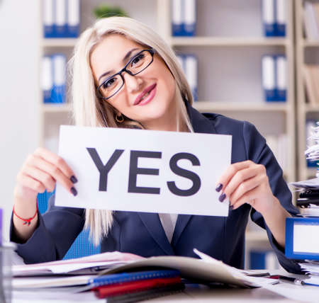 Businesswoman with message in office at deskの写真素材