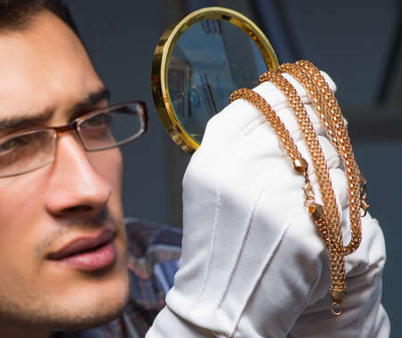 Young male jeweller working at night in his workshop