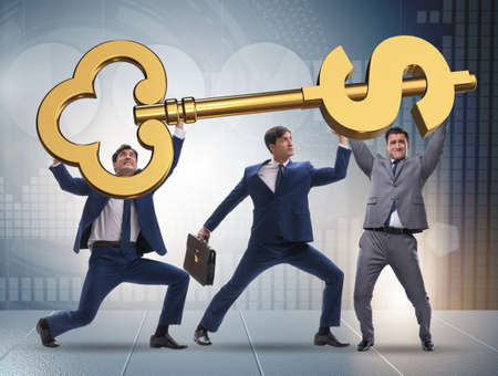 Businessmen holding giant key in finance conceptの写真素材