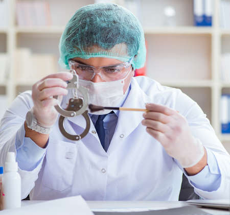 Criminologist police chemist looking at crime evidenceの写真素材