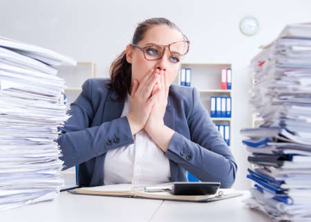 Tired businesswoman with paperwork workloadの写真素材