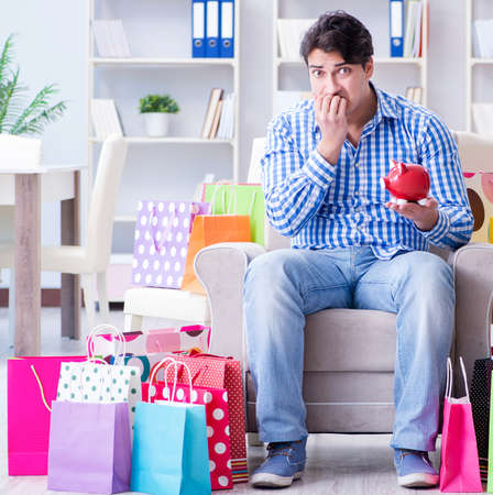 Young man after excessive shopping at homeの写真素材