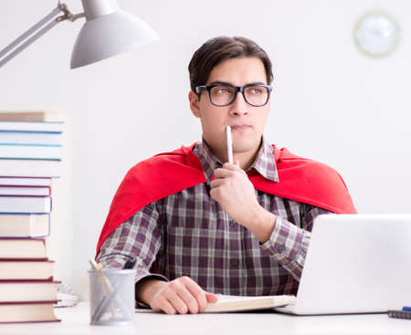 Super hero student with a laptop studying preparing for examsの写真素材