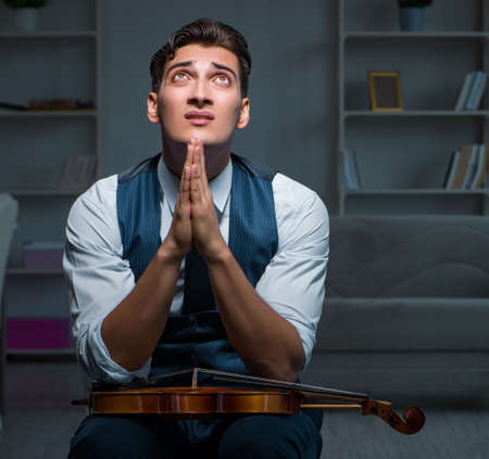 Young musician man practicing playing violin at home