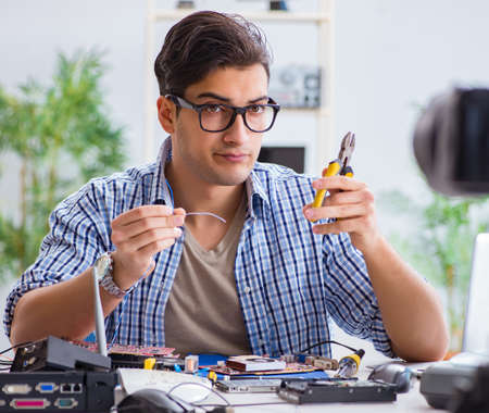 Vlogger recording computer repair on camera for vlog blog