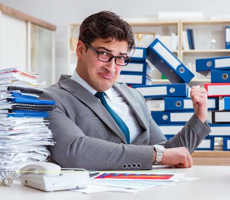 Businessman busy with much paperworkの写真素材
