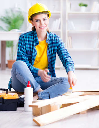 Female repairman carpenter cutting joining wooden planks doing rの写真素材
