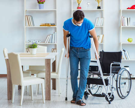 Young man recovering after surgery at home with crutches and a wの写真素材