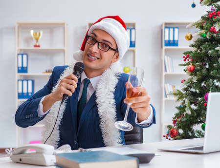 Businessman celebrating christmas holiday in the officeの写真素材