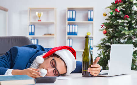 Businessman celebrating christmas holiday in the officeの写真素材