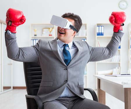 Man boxing in the office with virtual reality gogglesの写真素材