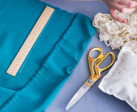 Woman tailor working on a clothing sewing stitching measuring fa