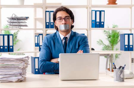 Young male employee with tape on the mouth