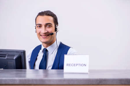 Young man receptionist at the hotel counterの写真素材