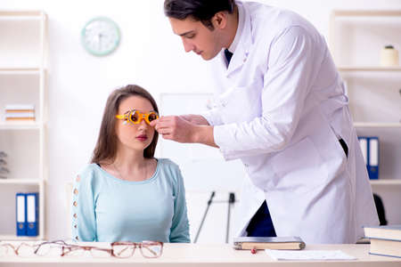 Young woman visiting male doctor oculistの写真素材
