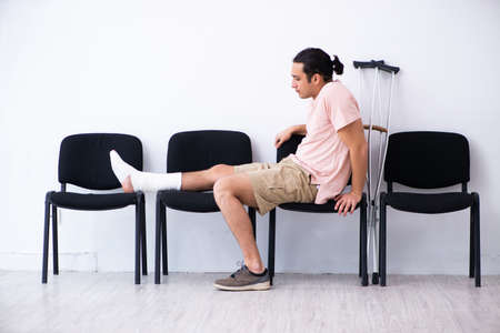 Young injured man waiting for his turn in hospital hall