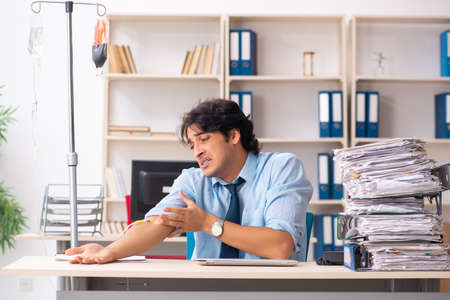 Young male employee in blood transfusion conceptの写真素材