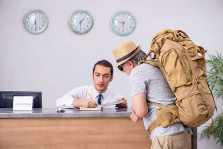 Backpacker at the hotel receptionの写真素材