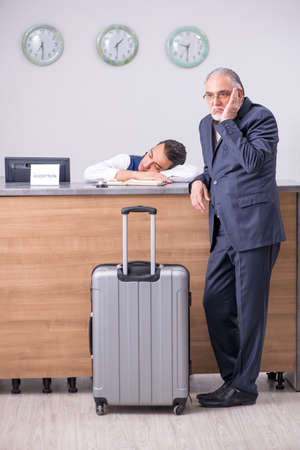 Old businessman at the hotel receptionの写真素材