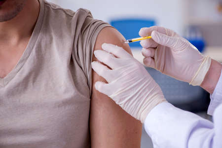 Male patient visitng doctor for shot inoculation