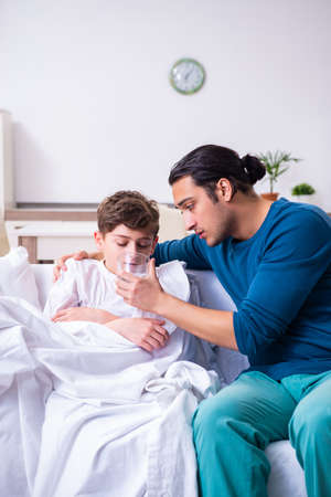 Young father caring for sick sonの写真素材