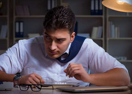 Businessman staying late in office for drugsの写真素材