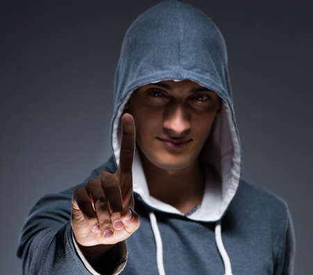 Young man wearing hoodie pressing virtual buttonsの写真素材