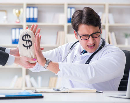 Young doctor in medical insurance fraud conceptの写真素材