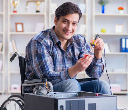 Computer repairman on wheelchair workingの写真素材