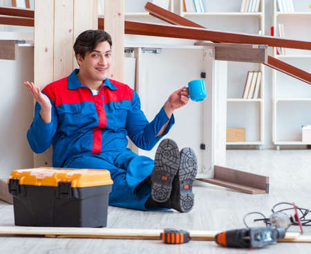 Young carpenter taking break from working with wooden planksの写真素材