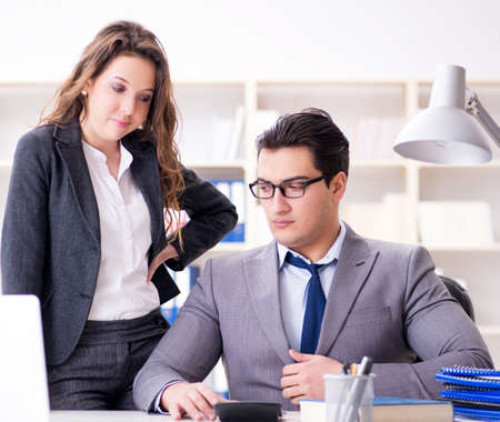 Sexual harassment concept with man and woman in officeの写真素材