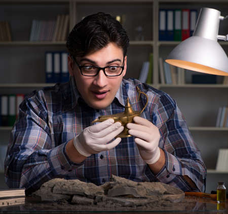 Archeologist working late night in officeの写真素材