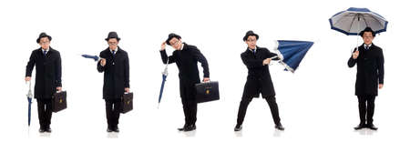 Young man holding suitcase and umbrella isolated on whiteの写真素材