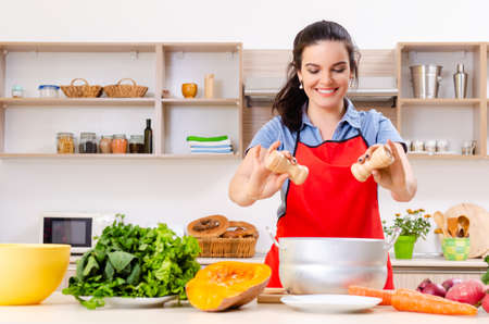 The young woman with vegetables in the kitchen