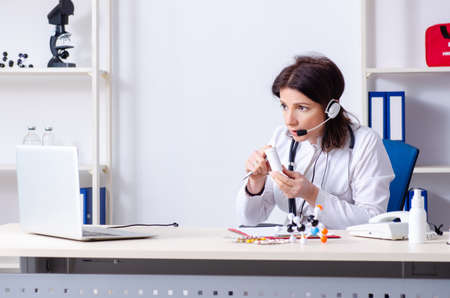 Middle-aged female doctor in telemedicine conceptの写真素材