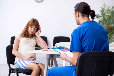 Pregnant woman visiting male doctor gynecologistの写真素材
