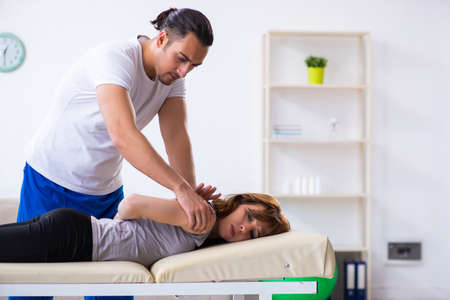 Young woman visiting male doctor physiotherapistの写真素材