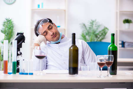 Male chemist examining wine samples at labの写真素材
