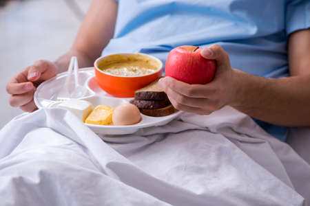 The male patient eating food in the hospitalの写真素材