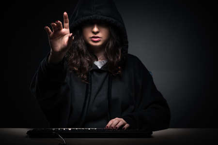 Female hacker hacking security firewall late in officeの写真素材