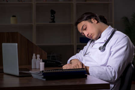 Young male doctor in the hospital at nightの写真素材