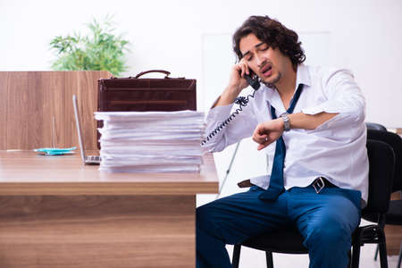 Young male employee unhappy with excessive workの写真素材