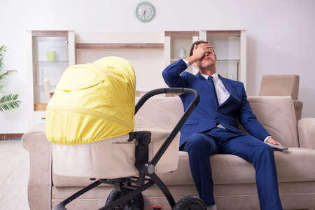 Young businessman looking after babyの写真素材