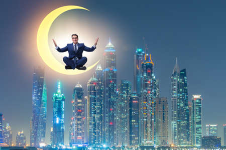 Businessman sitting on the crescent moonの写真素材