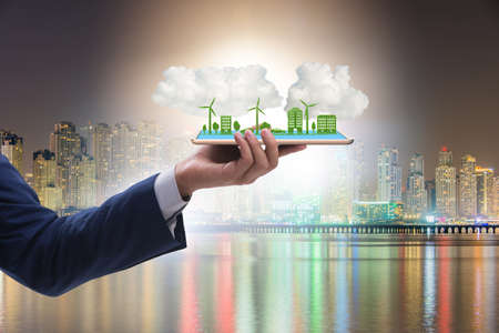 Hand holding tablet with mini ecosystem and clean energy