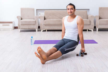 Young man training and exercising at homeの写真素材