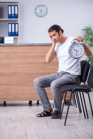 Young man at hospital reception deskの写真素材