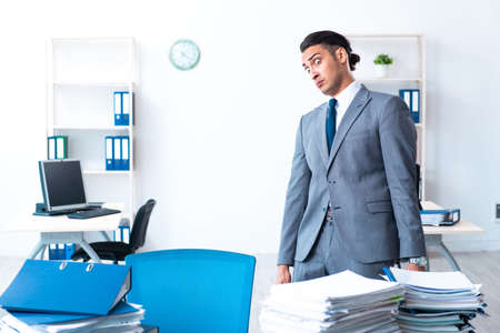 Businessman with heavy paperwork workloadの写真素材