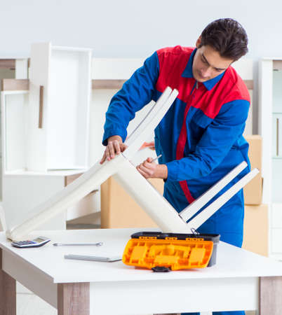 Contractor repairman assembling furniture under woman supervisioの写真素材